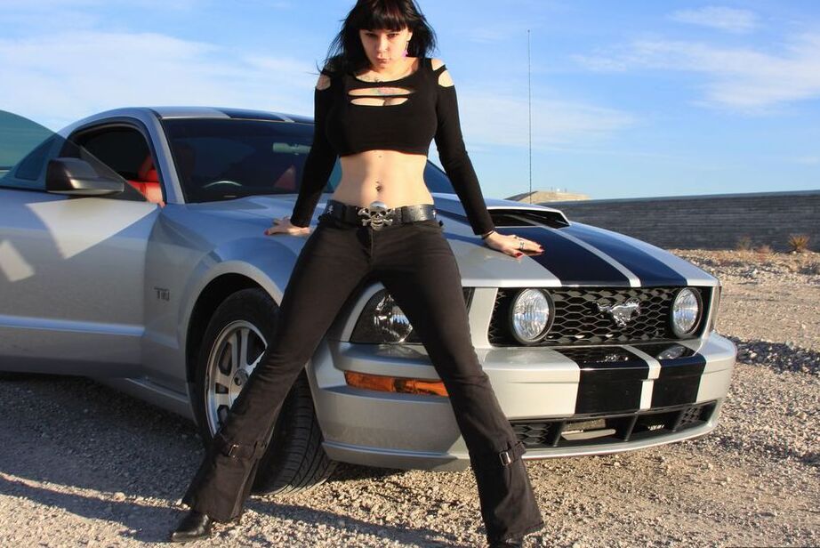20P Brunette amateur Susy Rocks models by a muscle car during a safe for work gig