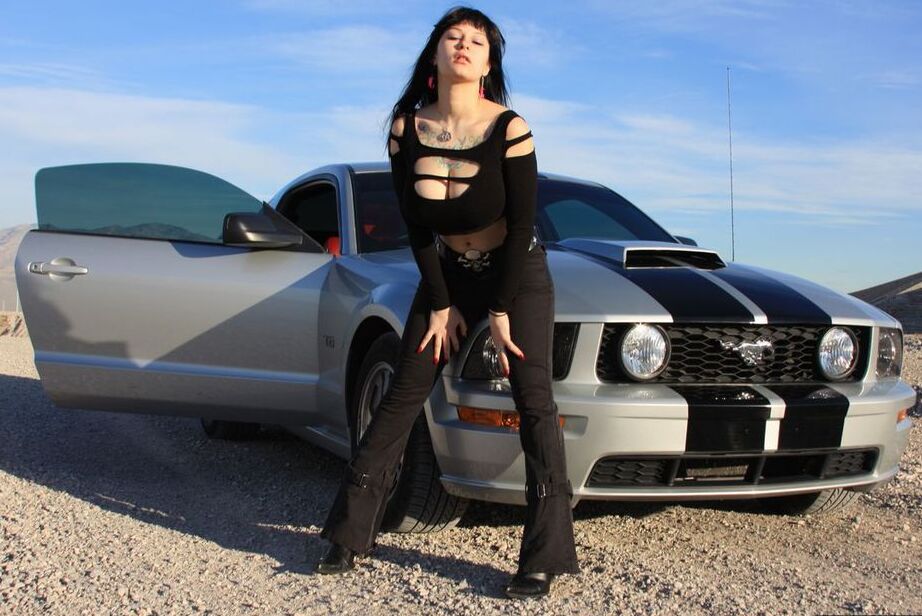 20P Brunette amateur Susy Rocks models by a muscle car during a safe for work gig