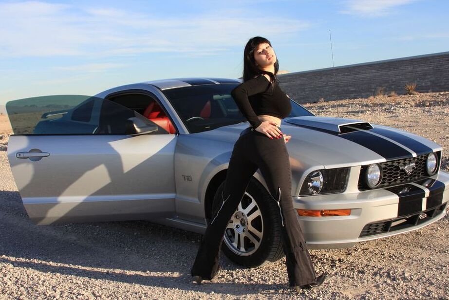 20P Brunette amateur Susy Rocks models by a muscle car during a safe for work gig