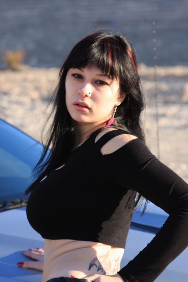 20P Brunette amateur Susy Rocks models by a muscle car during a safe for work gig