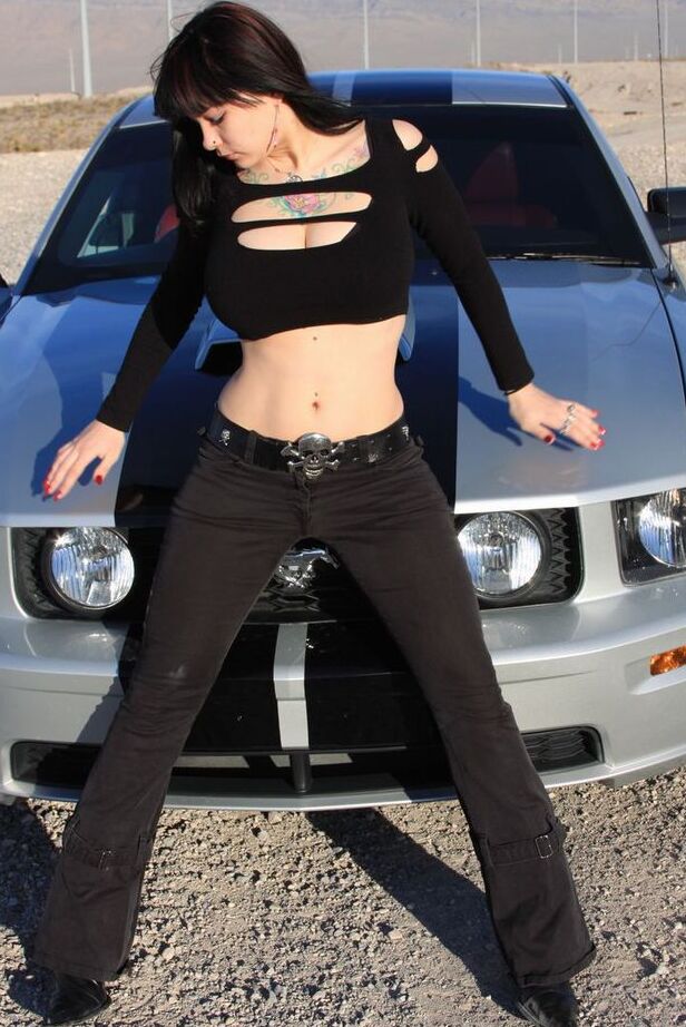 20P Brunette amateur Susy Rocks models by a muscle car during a safe for work gig