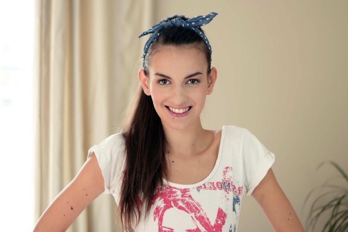 16P Une ado brune souriante joue avec sa fleur savoureuse et mouillée