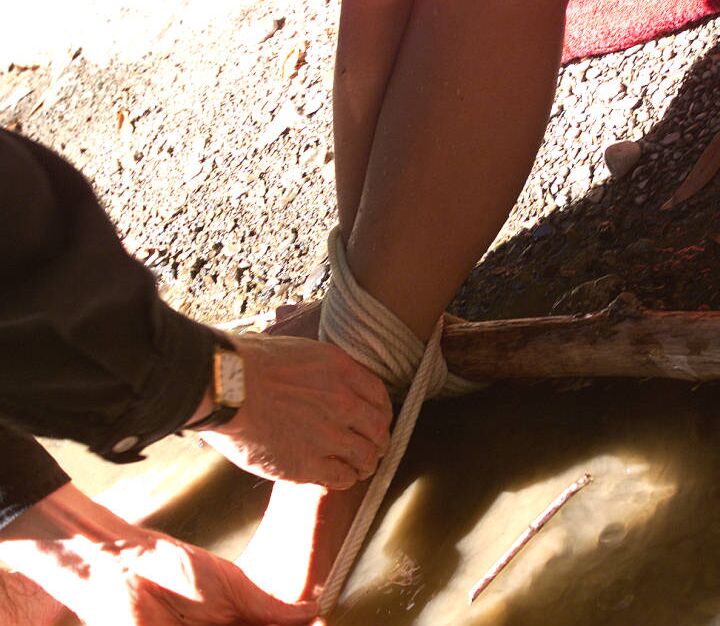 12P Chica rubia atada de manos y muñecas después de ser amordazada con una pelota a la orilla del río