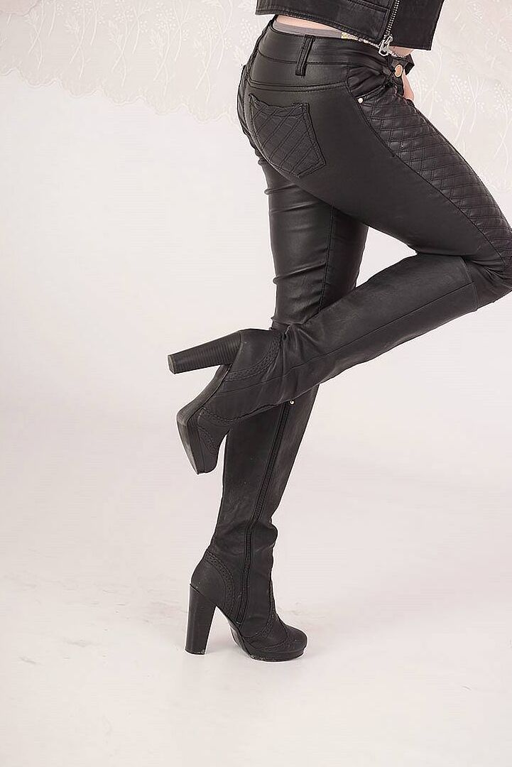 15P Mulher loira mostra os seios usando uma roupa toda de couro e botas