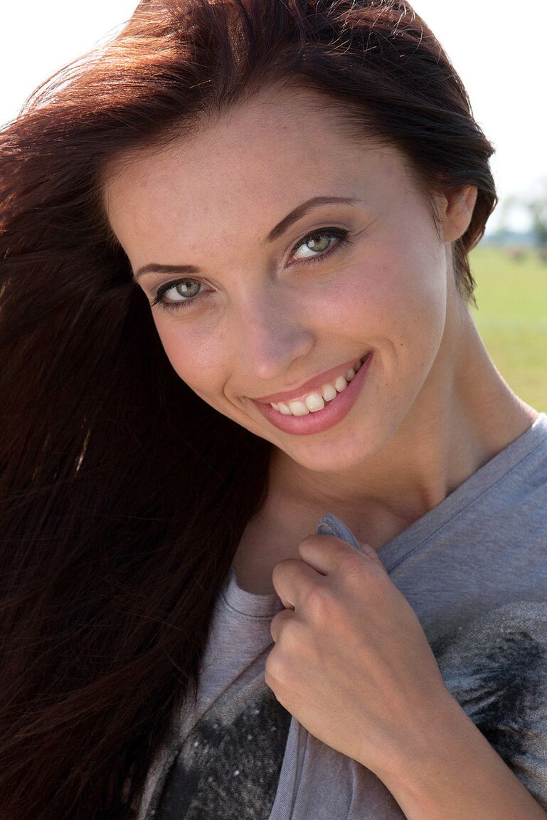 16P Young redhead Sollana pinches a nipple as she gets naked in a hay field