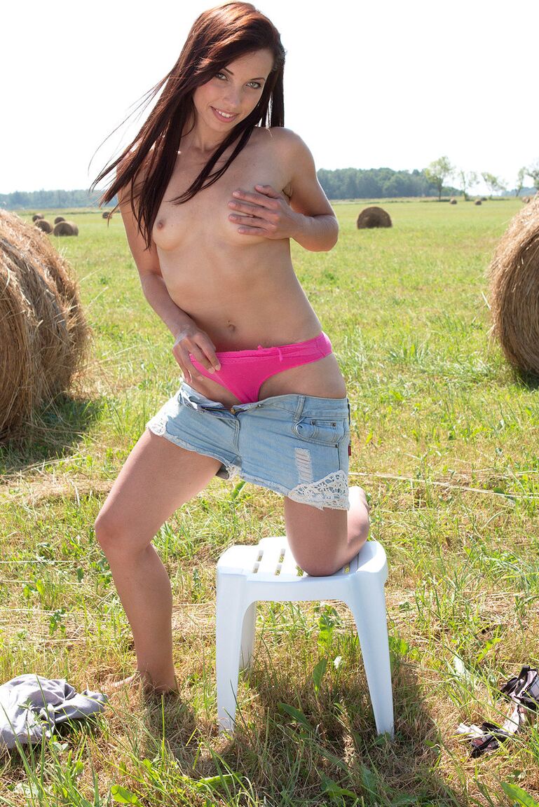 16P Young redhead Sollana pinches a nipple as she gets naked in a hay field