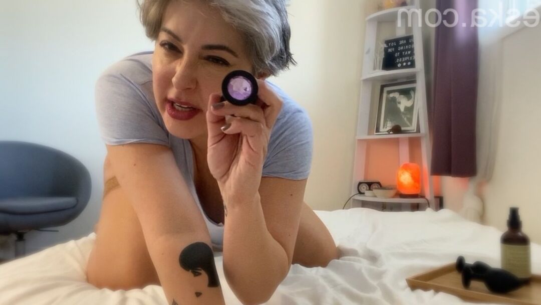 15P A loira platinada mais velha, Seska, enfia um plug anal em sua cavidade anal em uma cama