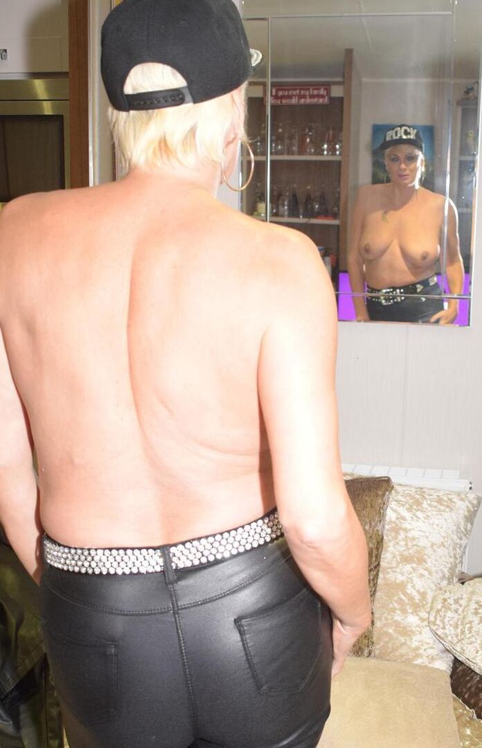 16P La blonde mature Dimonty enlève sa veste en cuir et son pantalon pour poser nue en bas.