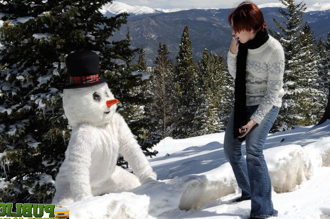 21P Naughty redhead Brandi de Lafey gives a snowman a CFNM handjob in the woods