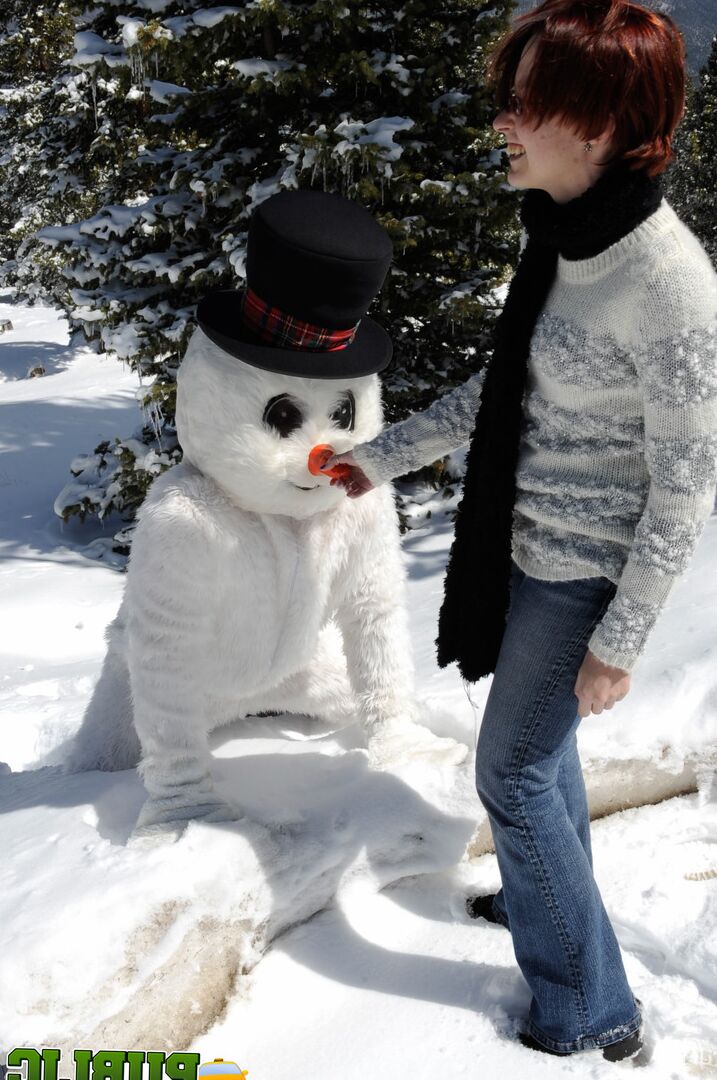 21P Naughty redhead Brandi de Lafey gives a snowman a CFNM handjob in the woods