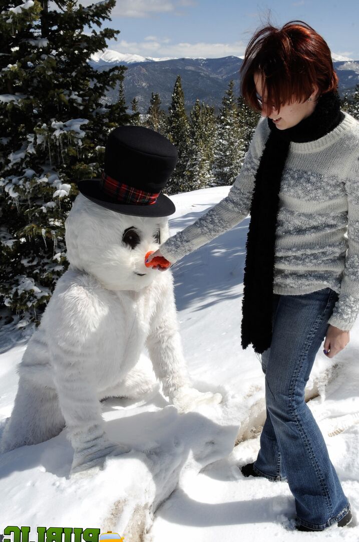 21P Naughty redhead Brandi de Lafey gives a snowman a CFNM handjob in the woods