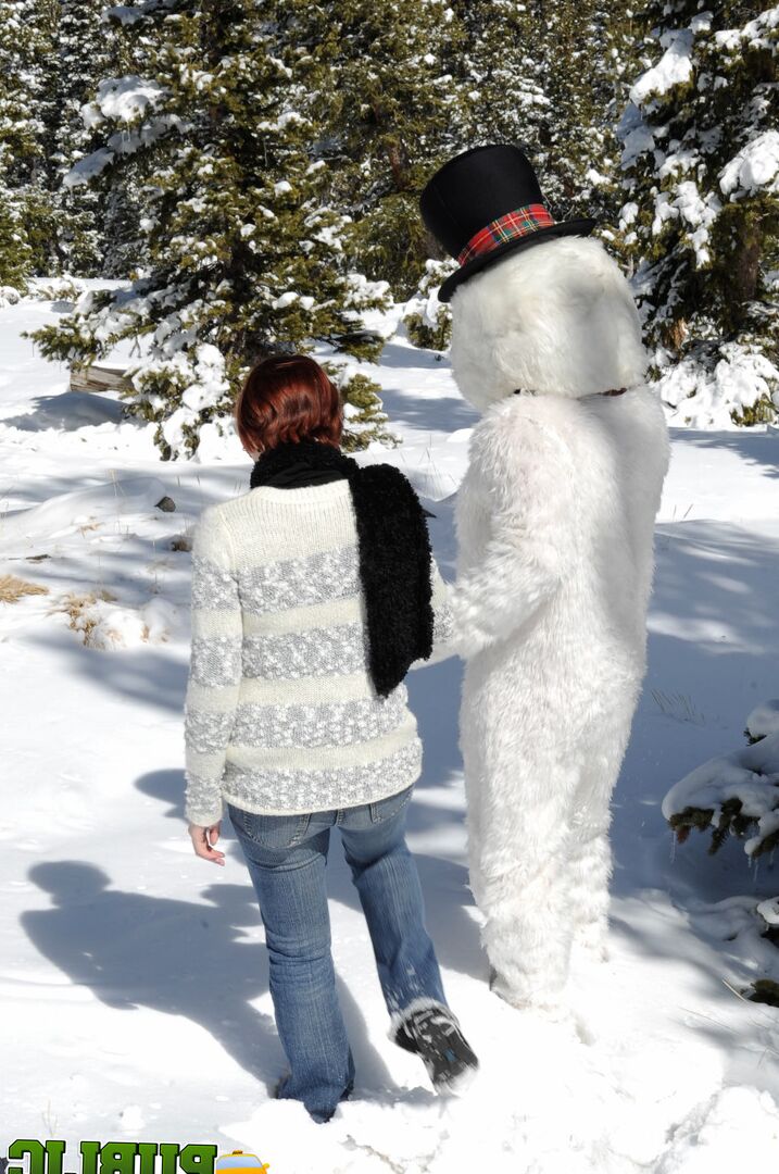 21P Naughty redhead Brandi de Lafey gives a snowman a CFNM handjob in the woods