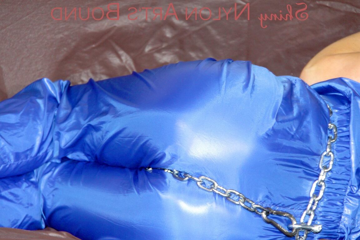 16P PIA tied and gagged with a pillory on a sofa wearing a sexy blue really shiny