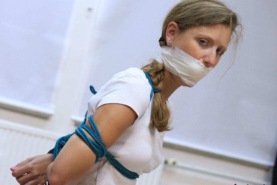 16P Caucasian female is silenced with a gag while tied to a chair in bare feet