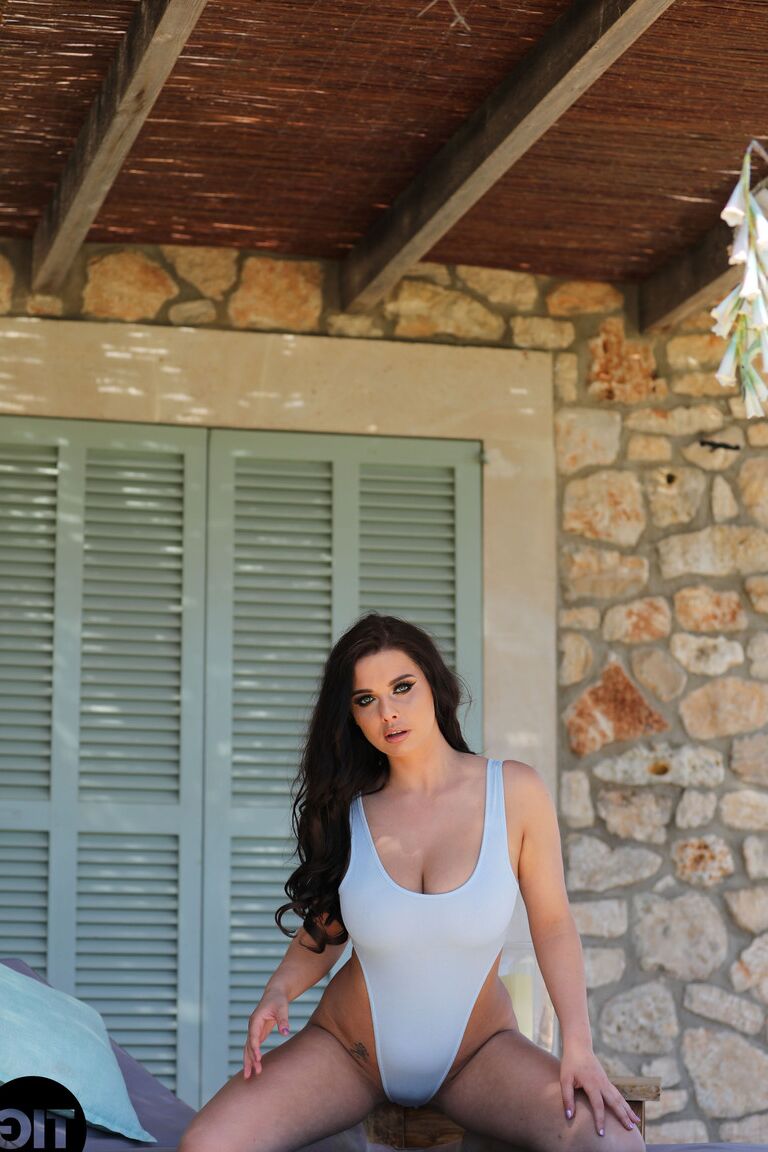 21P Black haired centerfold Kym Graham exposes her nice breasts in a solo