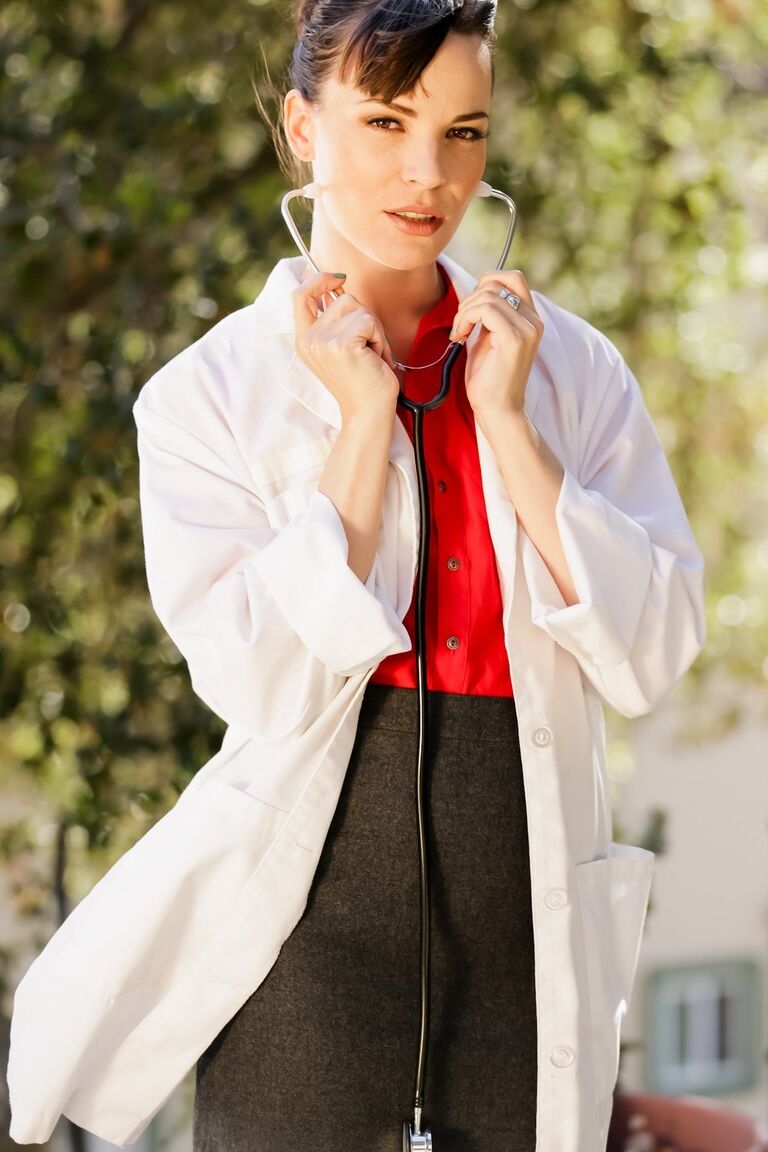 15P Female doctor Dana DeArmond takes off lab coat on way to posing in the nude