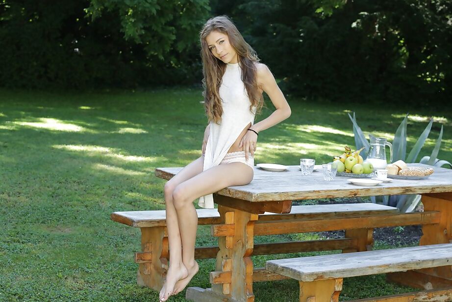 12P Jovem pornstar Rebel Lynn modelando topless em cima de uma mesa de piquenique no quintal