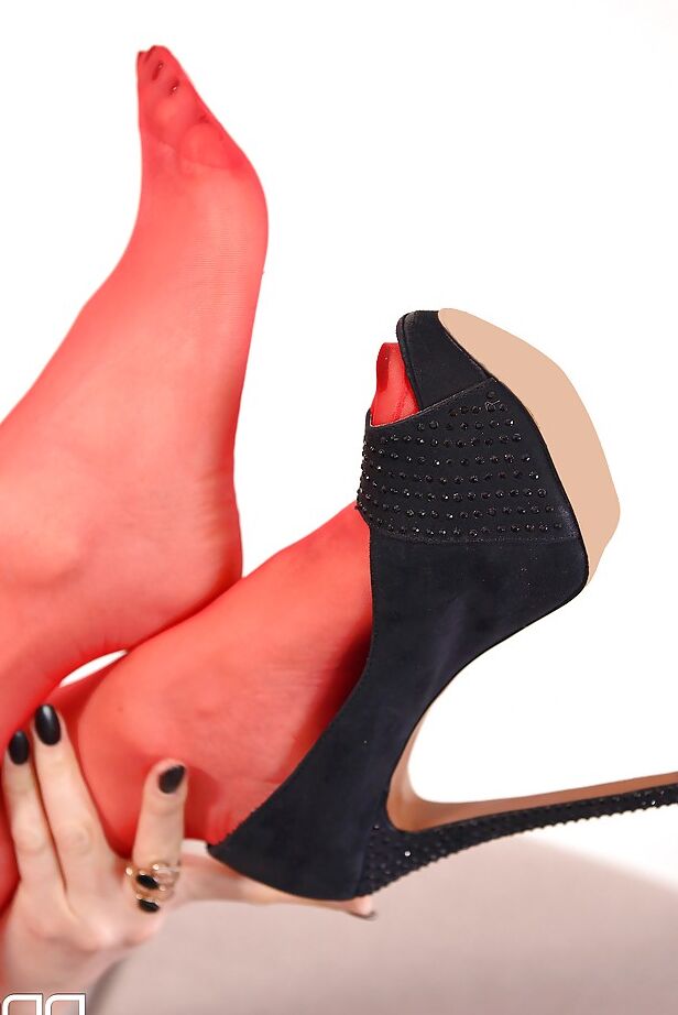 16P La fille solo Yasmin Scott enlève les talons hauts de ses pieds vêtus de bas.