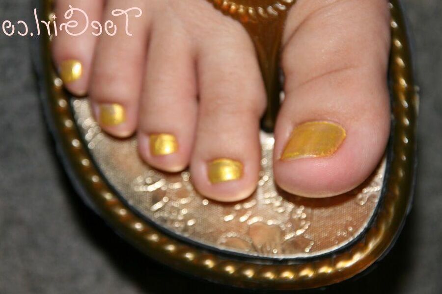 16P Mujer caucásica muestra las uñas de sus pies pintadas mientras usa sandalias