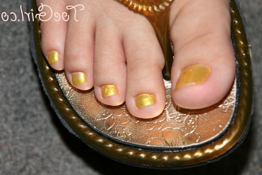 16P Mujer caucásica muestra las uñas de sus pies pintadas mientras usa sandalias