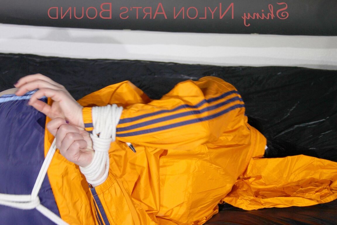 16P Люси связана веревками и кляпом во рту на диване в сексуальном синем блестящем нейлоне