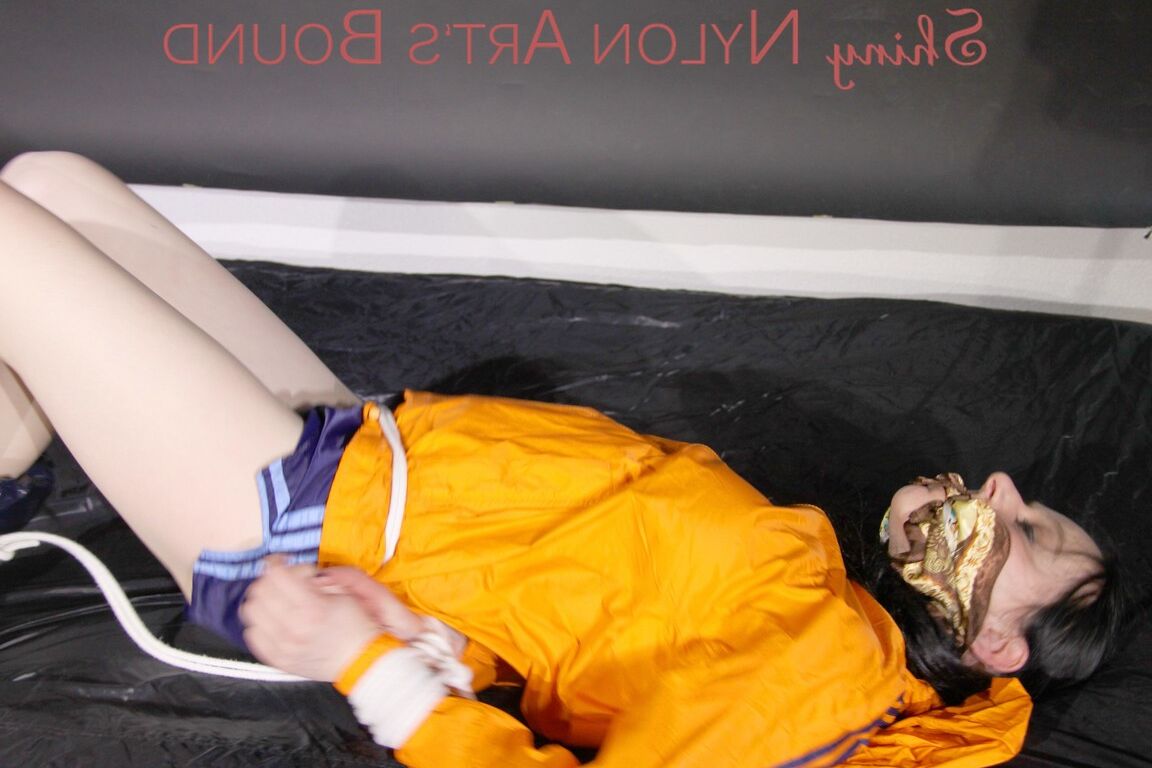 16P Люси связана веревками и кляпом во рту на диване в сексуальном синем блестящем нейлоне