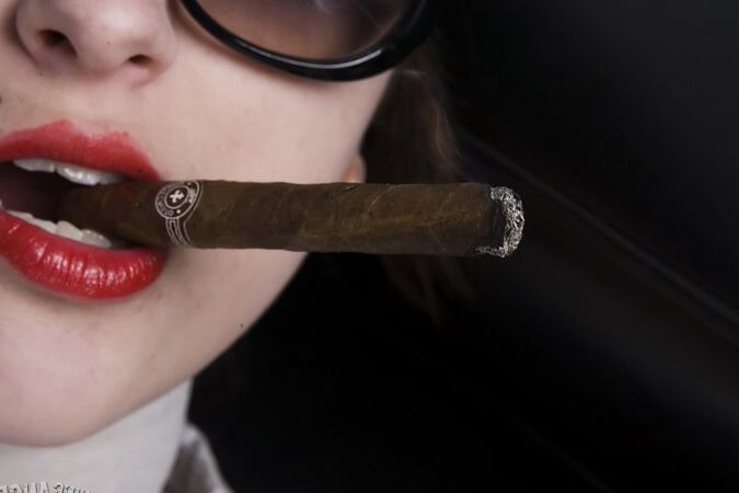 17P Une fille aux cheveux noirs se déshabille et se déshabille en fumant un cigare.