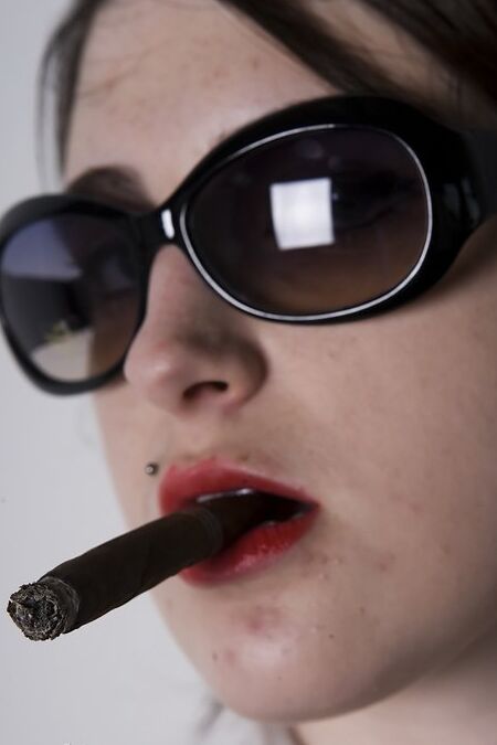 17P Une fille aux cheveux noirs se déshabille et se déshabille en fumant un cigare.