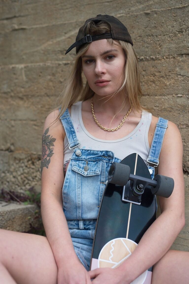 12P La patineuse blonde Pippa Doll se déshabille avant de descendre dans une rue pavée.