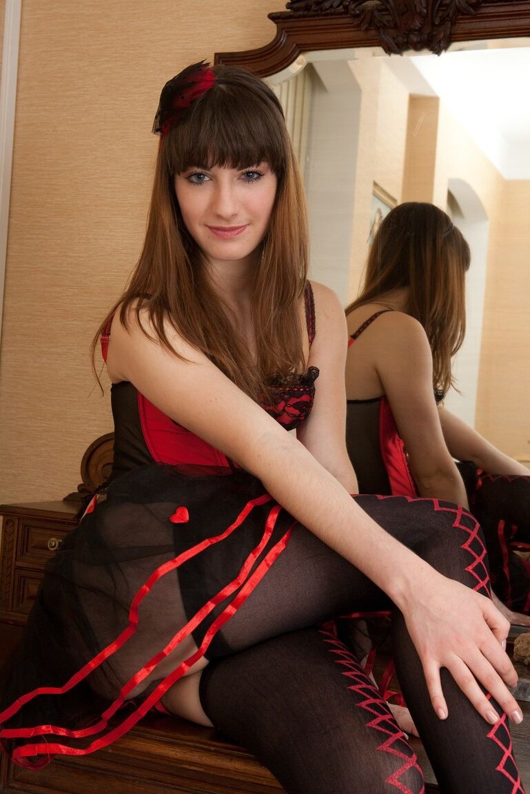11P Uma adolescente com cabelo castanho tira lentamente a lingerie sexy e as meias