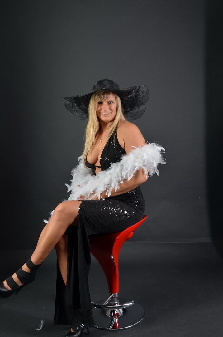 20P Middle-aged blonde Sweet Susi displays her tits and ass while in a big hat