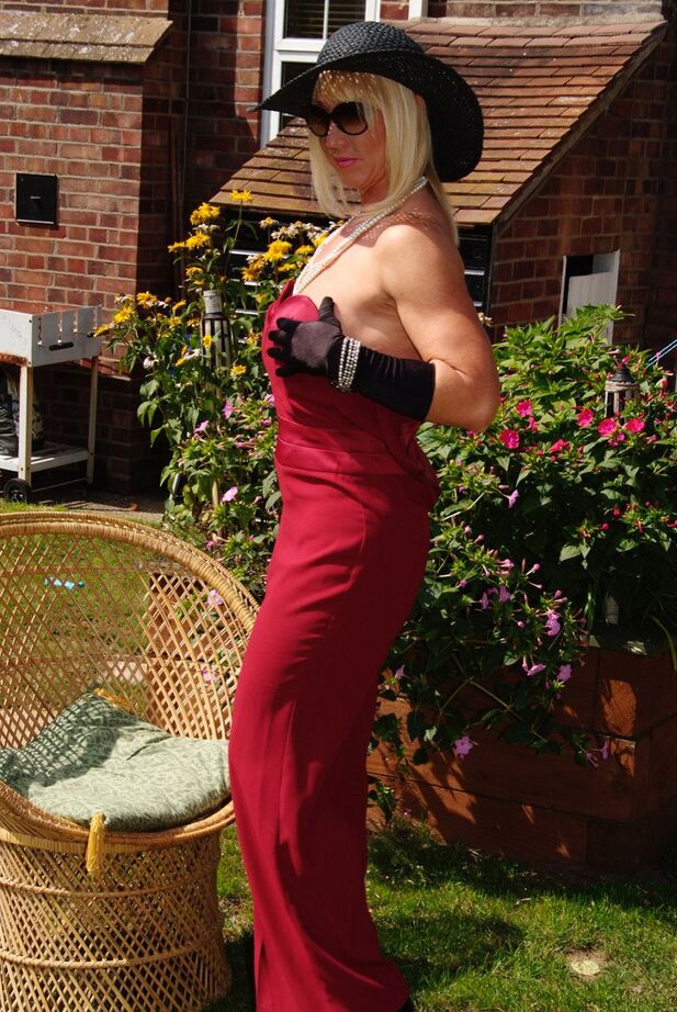 20P MILF blonde affiche ses gros seins dans un grand chapeau et des gants dans une cour