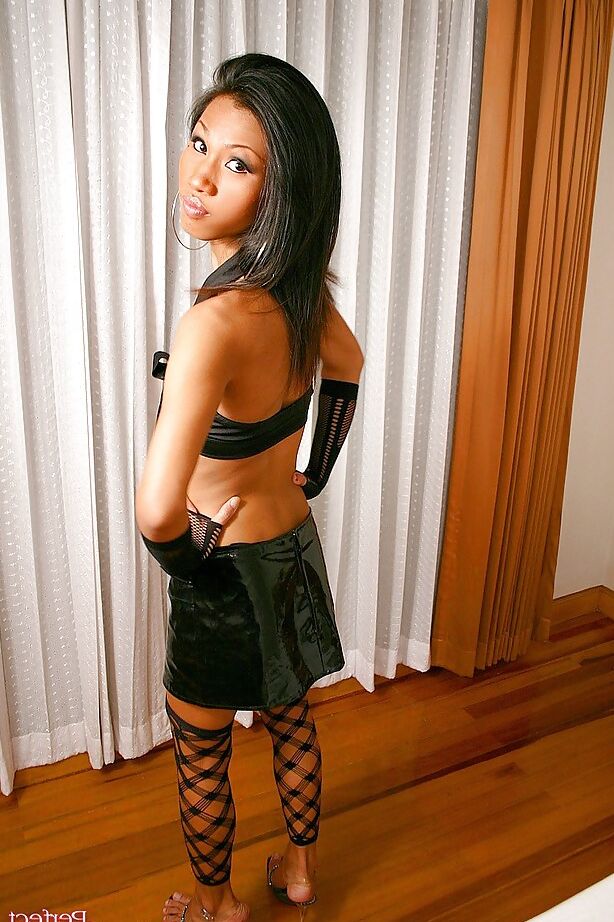16P La pequeña ladyboy asiática June posando con falda y medias negras