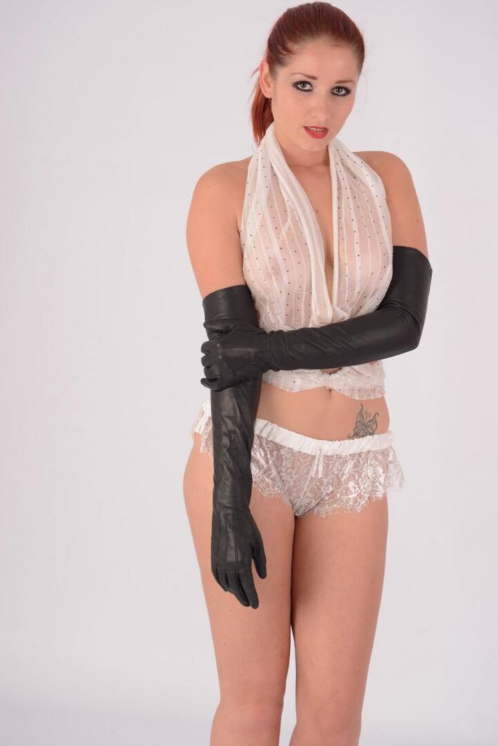 15P Une rousse sexy expose ses seins naturels tout en portant de longs gants en cuir