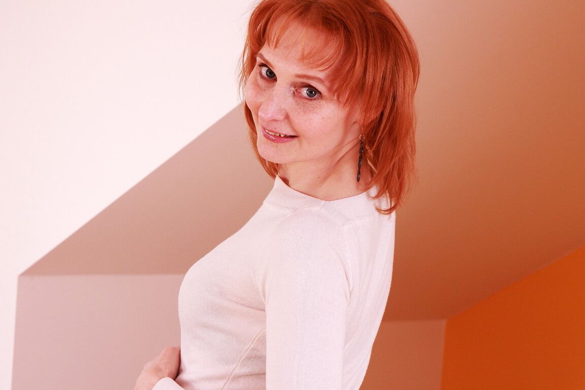 13P Older redhead highlights her hot ass while disrobing to stockings