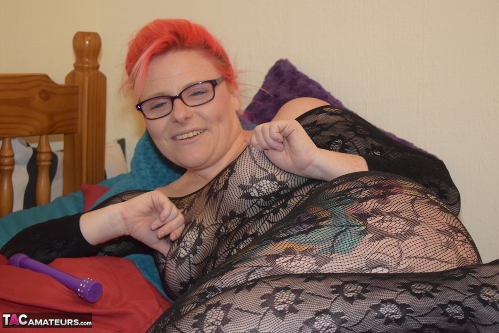 20P Redheaded amateur masturbates with a toy on her bed in a bodystocking