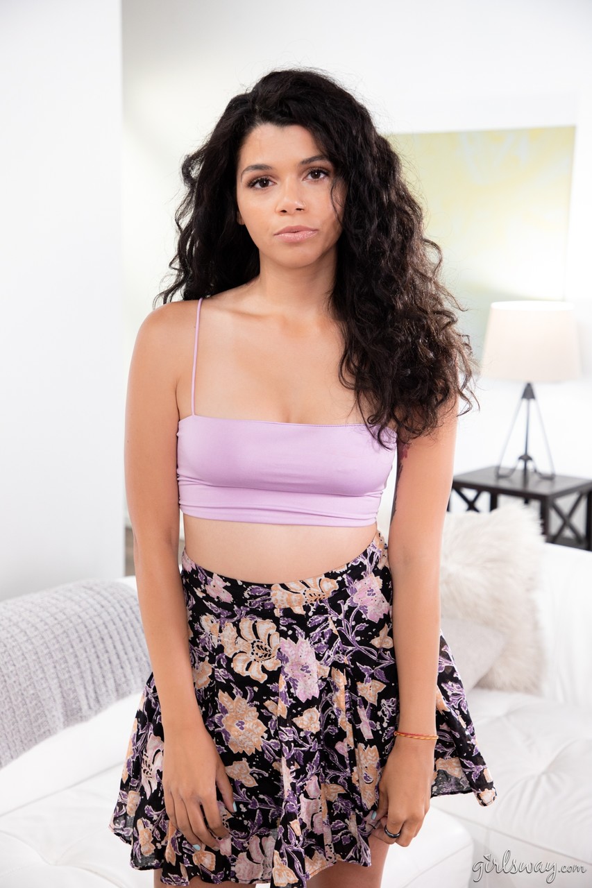 15P Brunette teen with a pretty face models non-nude in a floral print skirt