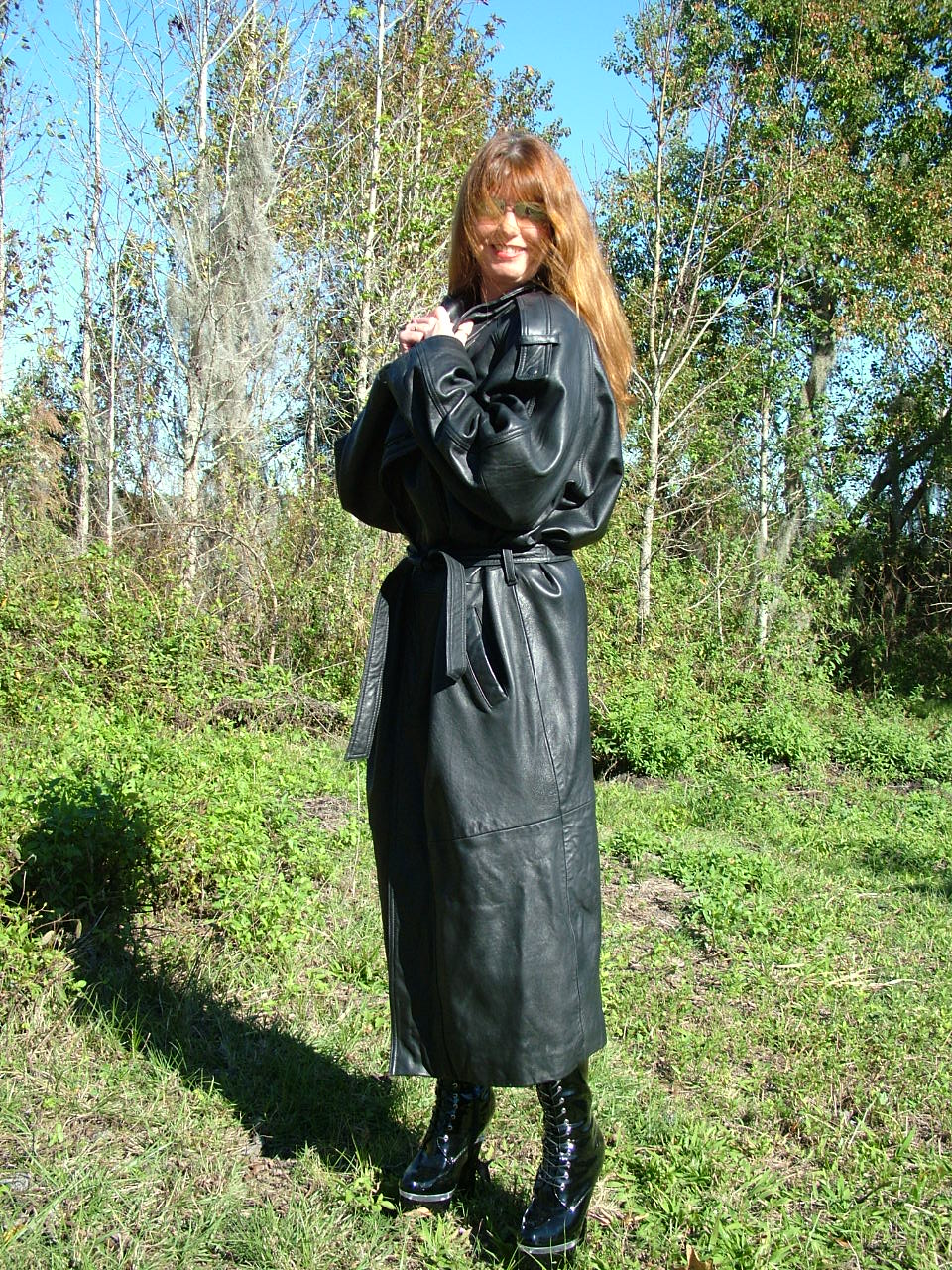 21P Une MILF en chaleur montre ses énormes seins et pose dans des bottes en cuir noir à l'extérieur