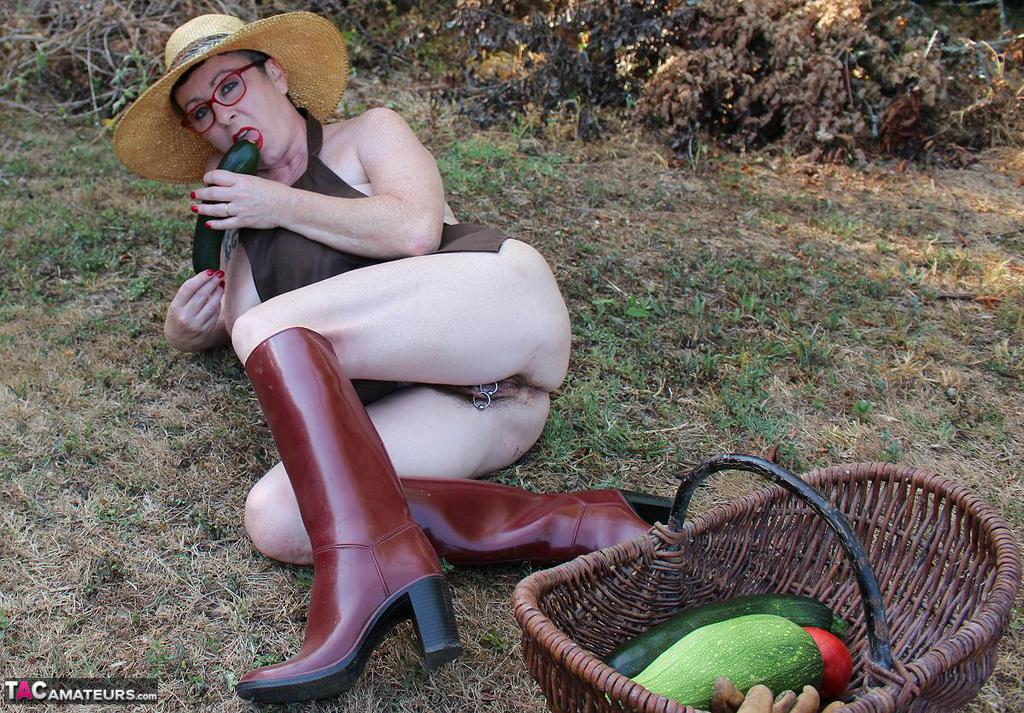 Die reife 20P-Frau Mary Bitch schiebt sich im Garten saisonales Gemüse in die Fotze