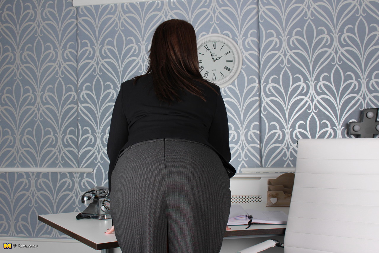 16P Mulher de negócios totalmente vestida mostra o sutiã e a bunda nua em sua mesa