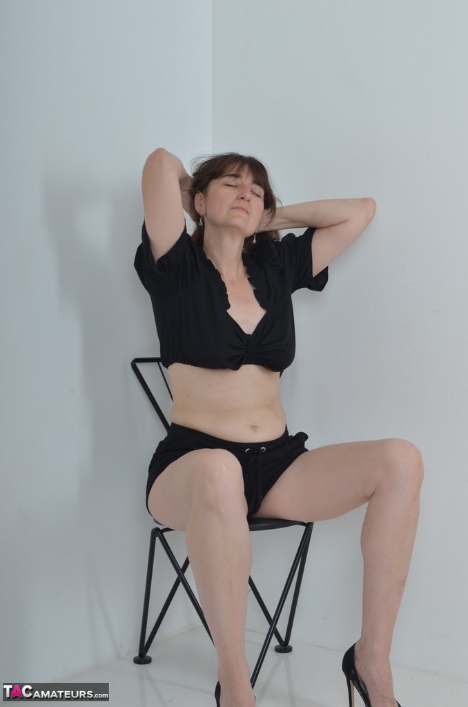 20P Amador mais velho Hot MILF senta em uma cadeira enquanto dedilha sua vagina raspada