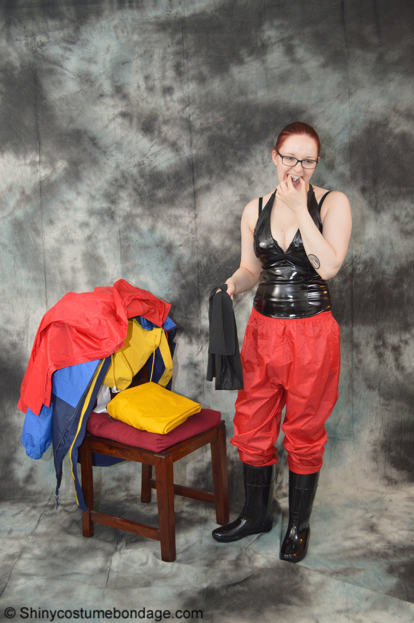 16P Pale redhead Lady Nadja dons a cleave gag while wearing rain suits