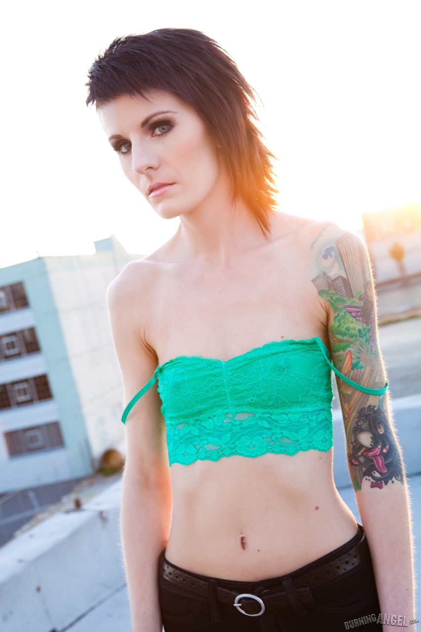 15P Gata alternativa magra com corpo tatuado expondo peitos minúsculos ao ar livre no telhado
