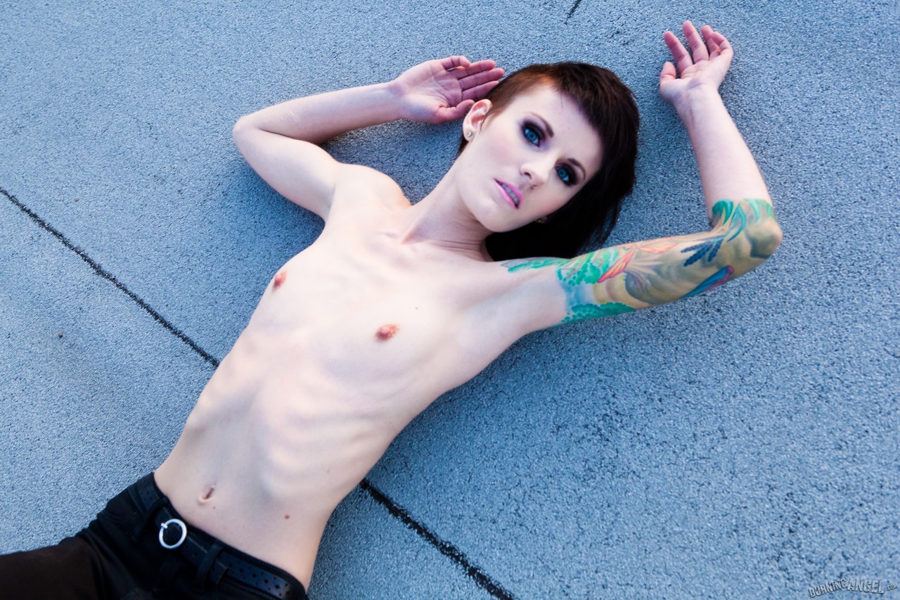 15P Gata alternativa magra com corpo tatuado expondo peitos minúsculos ao ar livre no telhado