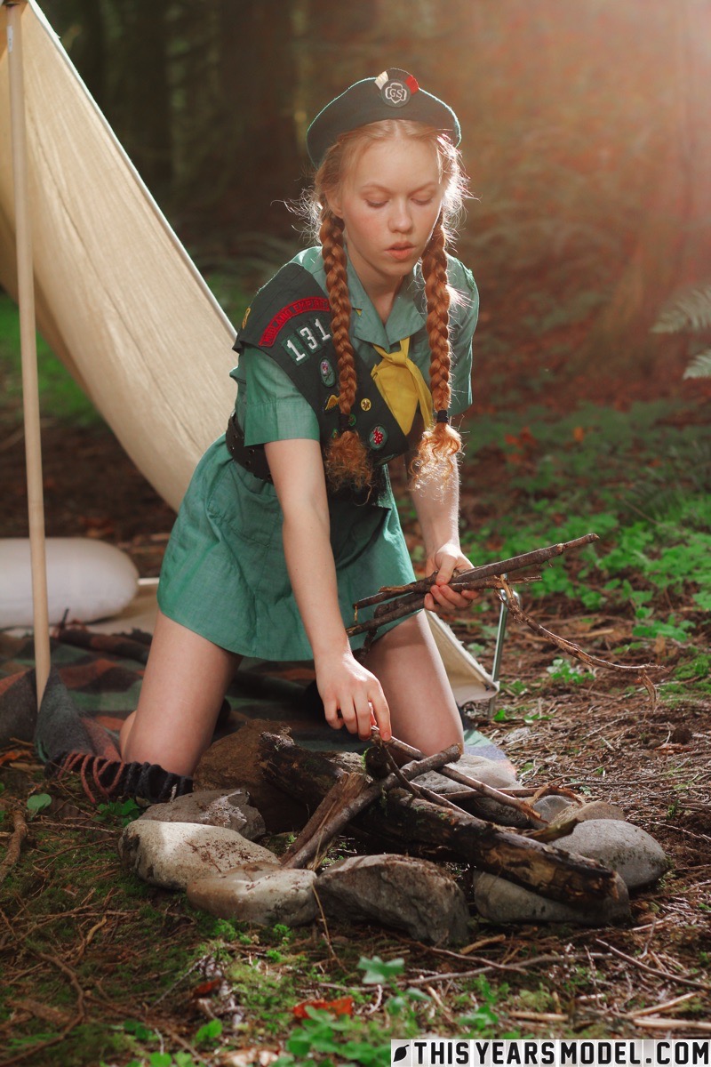 15P Dolly Little, une éclaireuse rousse, se déshabille devant sa tente avec un béret.