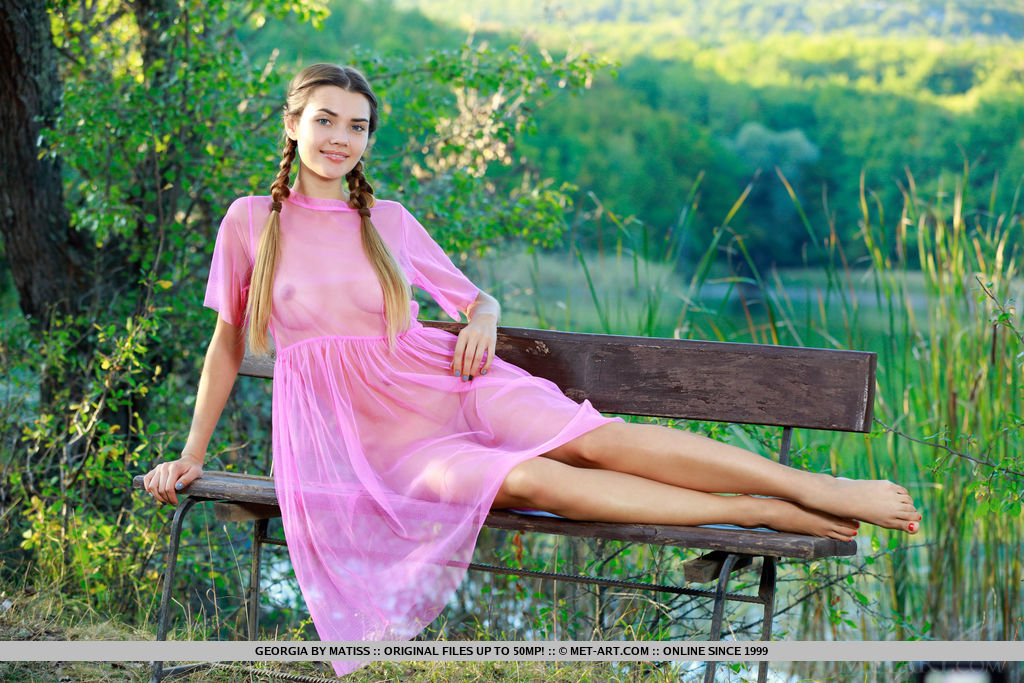 18P A adorável adolescente Georgia tira um vestido rosa transparente para posar nua em um mirante