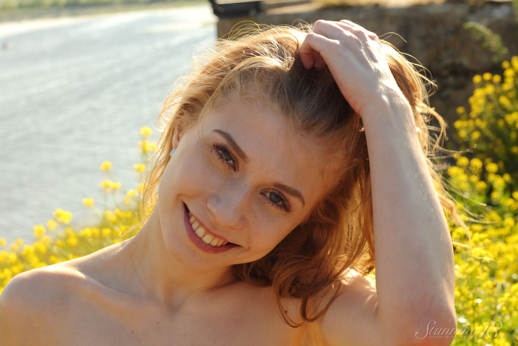 16P Young redhead Eva Gold thrusts her shaved pussy forward on a cliff in shoes