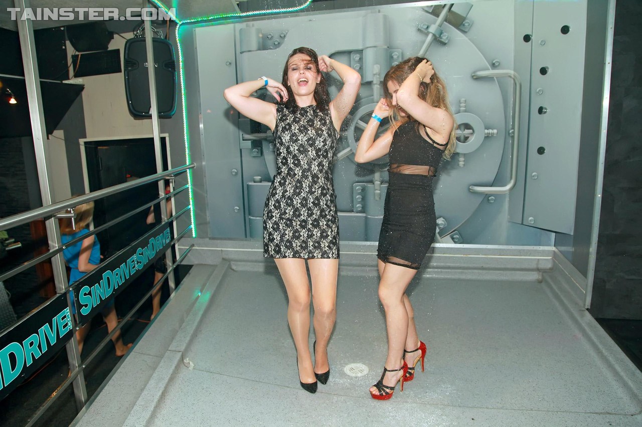 Las chicas del 15P Club comparten besos lésbicos después de empaparse bajo un aspersor
