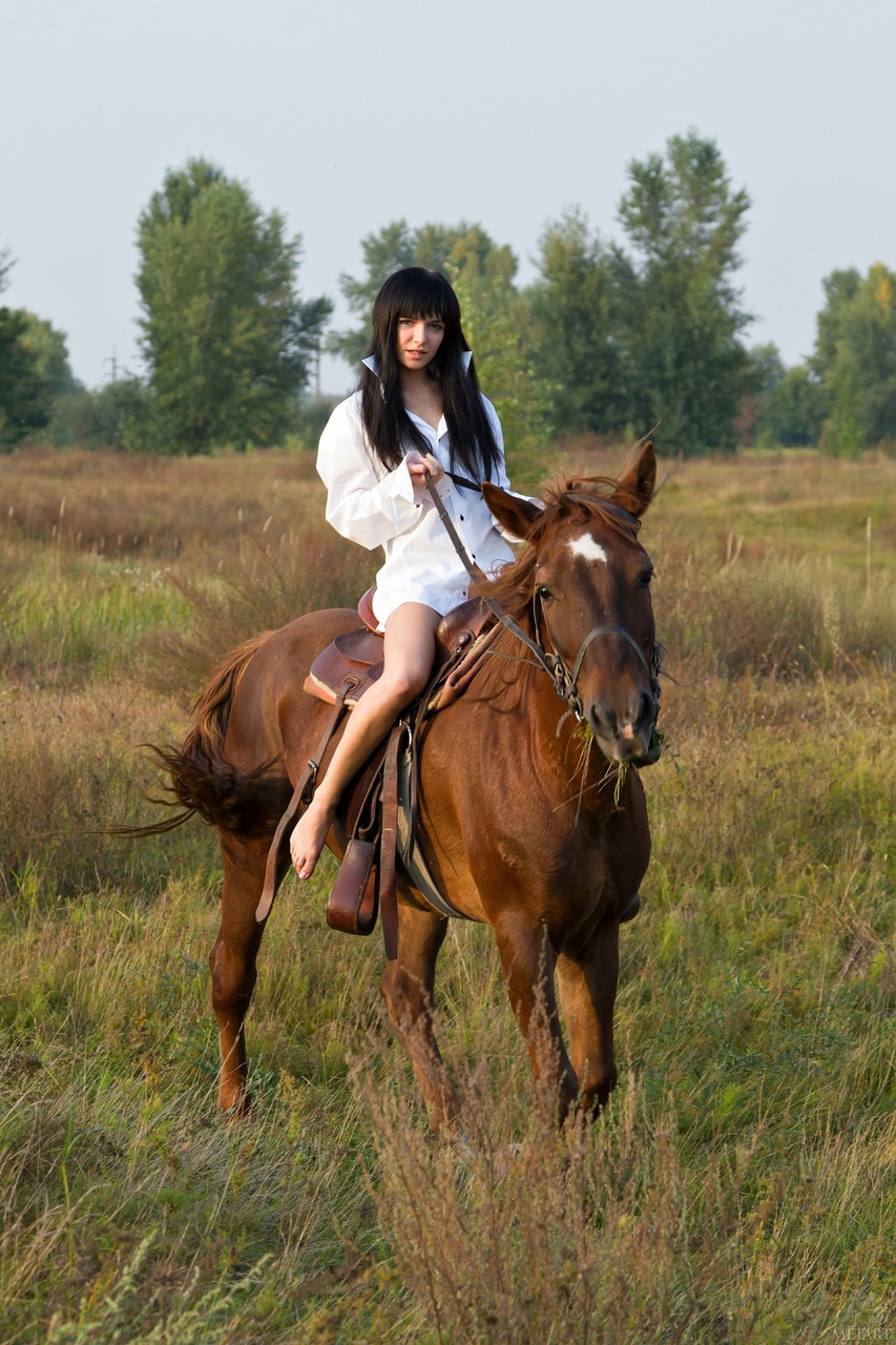21P Milania A, une adolescente naturelle, pose nue avec son cheval préféré sur le terrain