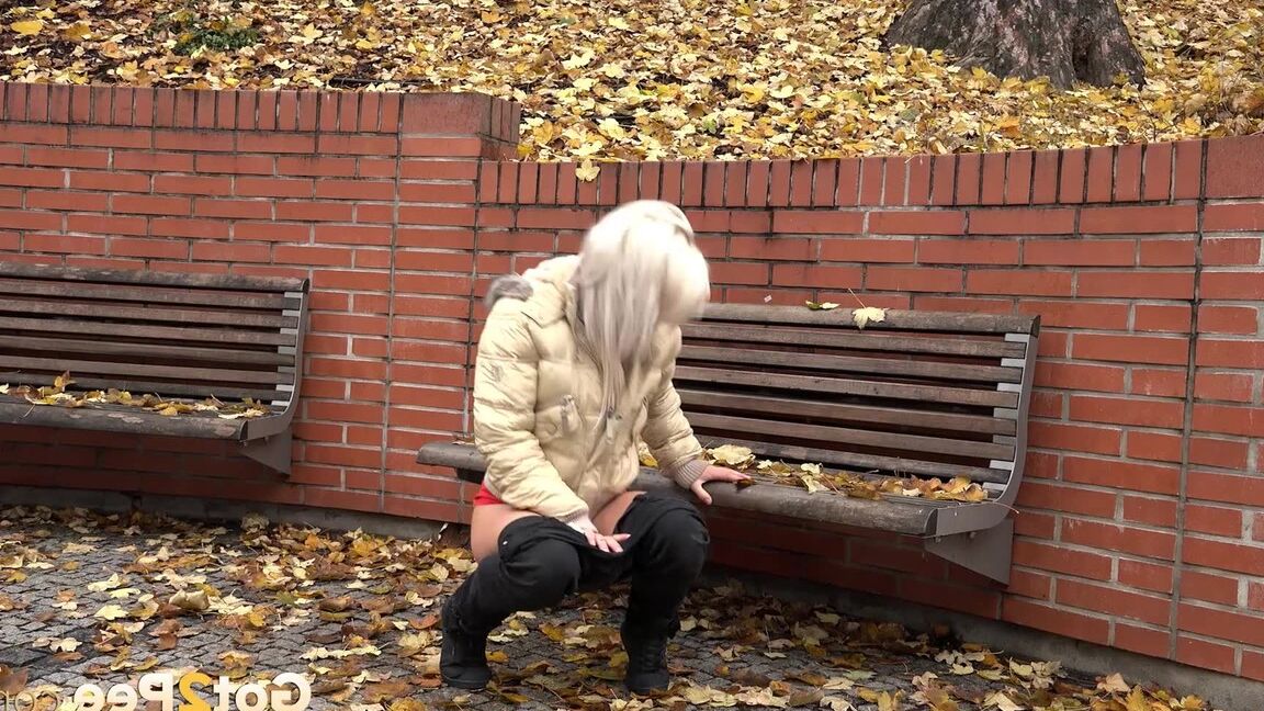 15P Clothed blonde Licky Lex pulls down dark leggings for a piss by a public bench